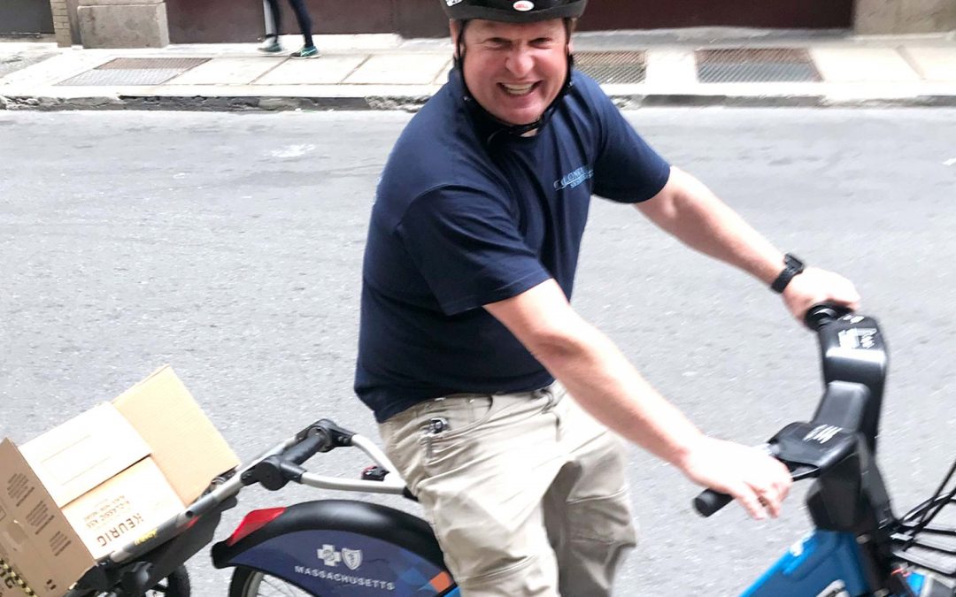 Colonial Systems installation foreman riding a bike from the Bluebikes bikesharing system